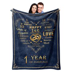 a man and woman holding up a blue blanket that says happy 1st anniversary to their love