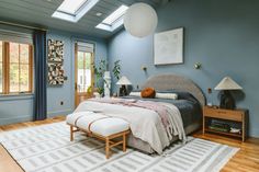 a bedroom with blue walls and wooden floors