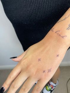 a woman's hand with stars on it, and the word love is written in cursive writing