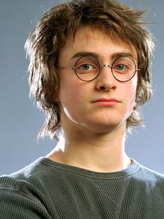 a young man wearing glasses and looking at the camera with a serious look on his face