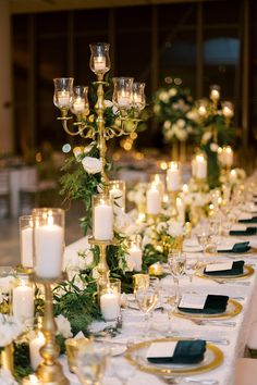 a long table is set with candles and flowers for a formal dinner or wedding reception