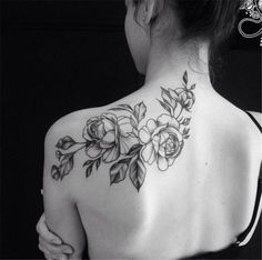 the back of a woman's shoulder with flowers on it