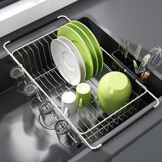 the dish rack is full of dishes and utensils in green, white or black