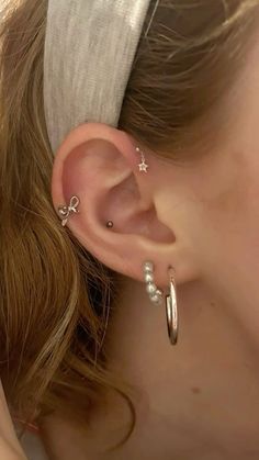 a close up of a person wearing some kind of ear cuff with pearls on it