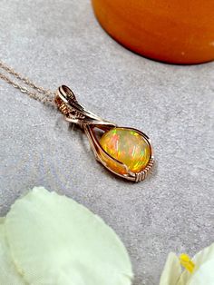 This wire wrapped opal pendant features a gorgeous Ethiopian Welo opal wire wrapped in 14k rose gold filled wire.  The opal is photographed in direct sunlight and shade in order to show color saturation. About the Opal: - Genuine, natural gem-grade Ethiopian opal - 14.5 x 13.0mm - 7.8 carats - Surface Imperfections: none - Mosaic + broadflash pattern, full spectrum rainbow fire & full color saturation About the Pendant: - 100% handmade - 14k rose gold filled wire and chain - Non-tarnish - Safe f Gold Opal Necklace, Birthstone Jewelry Mothers, October Birthstone Jewelry, Rainbow Fire, Wrapped Jewelry, October Birthstone, Full Spectrum, Welo Opal, Gift For Wife