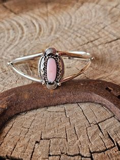 Discover the beauty of the ocean with our free form pink conch shell. Adorned with a leaf frame and two band cuff, this unique piece will bring a touch of nature to any outfit. Let the vibrant color and organic shapes inspire you every day. Pink Bohemian Adjustable Cuff Bracelet, Adjustable Pink Bohemian Cuff Bracelet, Bohemian Adjustable Pink Cuff Bracelet, Unique Adjustable Pink Cuff Bracelet, Pink Adjustable Cuff Bracelet, Adjustable Pink Cuff Bracelet, Adjustable Bohemian Pink Opal Jewelry, Bohemian Pink Bangle Jewelry, Adjustable Pink Oval Jewelry