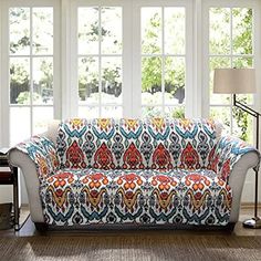 a living room scene with focus on the couch and rugs in front of the windows