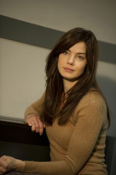 a woman is sitting down and posing for the camera