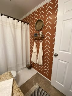 a bathroom with two towels hanging on the wall next to a toilet and shower curtain