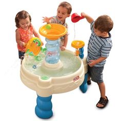 three children playing with an inflatable water fountain