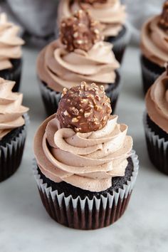 cupcakes with chocolate frosting and sprinkles on top are arranged in rows