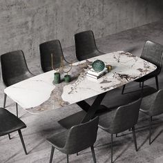 a marble dining table with six chairs around it and a book on the top, in front of a concrete wall