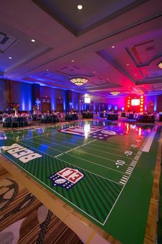 an indoor sports field is lit up with purple and blue lights at the end of it