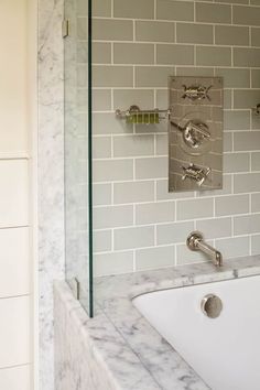 a bathroom with a sink, mirror and tiled walls