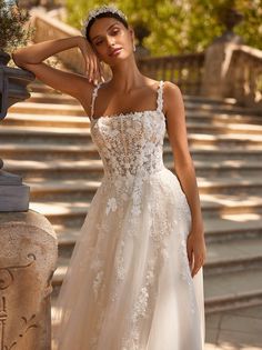 a woman in a wedding dress posing for the camera with her hand on her hip