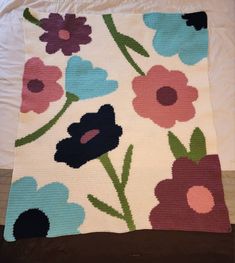 a crocheted blanket with flowers on it