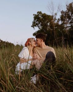 a man and woman sitting in tall grass