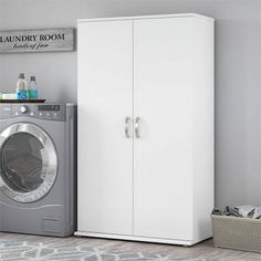 a laundry room with a washer and dryer next to each other in front of a white cabinet