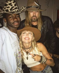 two men and a woman posing for the camera with cowboy hats on their heads at a party