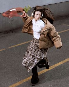 a woman with headphones is running and holding flowers