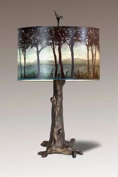 a lamp that is sitting on top of a wooden table with a painting on it