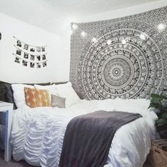 a bedroom with a large tapestry hanging on the wall and a bed in front of it