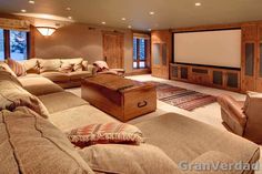 a large living room with couches, chairs and a projector screen in it