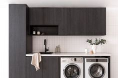 a washer and dryer in a room with white tile flooring on the walls