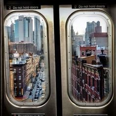 the view from inside an airplane window looking down on a cityscape with tall buildings