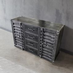 a metal cabinet sitting on top of a floor next to a wall