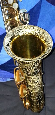 a brass instrument is sitting on a blue and white cloth