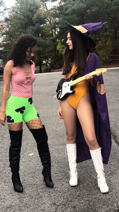 two women dressed up in costumes and holding guitars