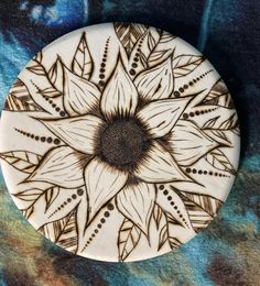 a white and black plate with an intricate design on the front, sitting on a blue background