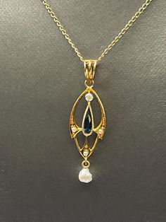 A gorgeous ladies antique pendant beautifully crafted in 14 karat solid yellow gold.  This amazing antique is set with a teardrop Sapphire in the center with a freshwater pearl that suspends gracefully at the bottom.  One round white minor cut diamond and three cultured pearls also accent this unique piece.  A triple loop bale secures this beauty to your favorite chain.  Looks fabulous on! Weight: 1.2 grams  Length:  1 ½" Width:  ⅜" Our Price $375.00  Regularly Priced At $550.00 Please See Our Video Remember - If you're purchasing for yourself or a gift for a loved one, buy with confidence.  We Guarantee Everything We Sell!  SKU # P644 Antique Pearl Pendant Necklace For Formal Occasions, Yellow Gold Teardrop Pearl Pendant Necklace, Yellow Gold Pearl Necklace With Teardrop Pendant, Heirloom Pearl Pendant Necklace, Victorian Teardrop Wedding Necklace, Yellow Gold Teardrop Necklace With Pearl Pendant, Victorian Gold Pearl Necklace With Pearl Drop, Antique Yellow Gold Pearl Necklace For Wedding, Formal Yellow Gold Drop Necklace With Pearl Pendant