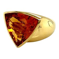 This 18k yellow gold ring features a stunning trillion-shaped citrine stone that will catch the eye of anyone who sees it. The citrine stone is carefully cut and polished to maximize its brilliant shine, creating a beautiful focal point for the piece. The warm, rich hue of the yellow gold beautifully complements the golden tones of the citrine, adding to its overall appeal. The band of the ring is crafted from high-quality 18k yellow gold, which provides a sturdy and durable foundation for the stone. The combination of the citrine and the yellow gold creates a luxurious and timeless look, making this ring a beautiful addition to any jewelry collection. Whether worn as a statement piece or as an elegant everyday accessory, this 18k yellow gold and trillion-shaped citrine ring is sure to del Luxury Elegant Trillion Cut Ring, Yellow Gold Trillion Cut Jewelry With Accent Stones, Fine Jewelry Yellow Gold Trillion Cut Ring, Classic Trillion Cut Yellow Gold Jewelry, Yellow Gold Trillion Cut Gemstone Jewelry, Luxury Yellow Citrine Rings, Citrine Ring, Citrine Stone, Everyday Accessories