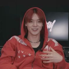 a young man with red hair wearing a red hoodie