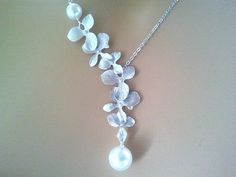 a white necklace with flowers and pearls on it