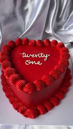 a heart shaped cake with the words twenty one written on it in cursive writing