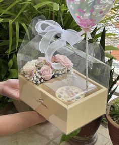 a box with some flowers and a balloon in it