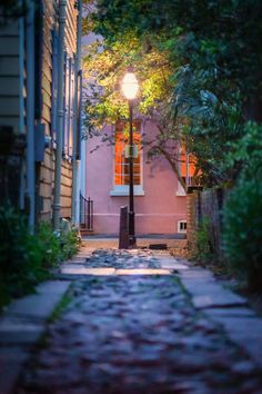 an alley way with a lamp post and trees