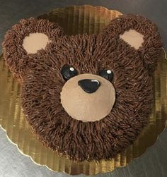 a cake with chocolate frosting and a teddy bear face