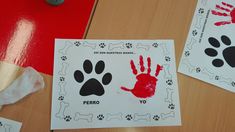 two handprints with red and black paw prints on them next to a roll of toilet paper