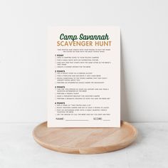 a camp savannah scavenger hunt printable on a wooden stand with a white wall in the background