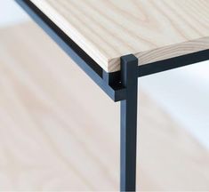 a wooden table with black metal legs and a wood grained surface on the top