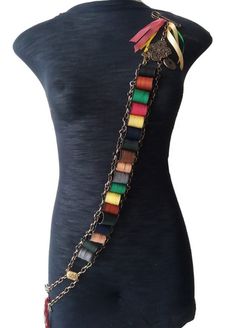 a mannequin wearing a multicolored belt with chains and tassels