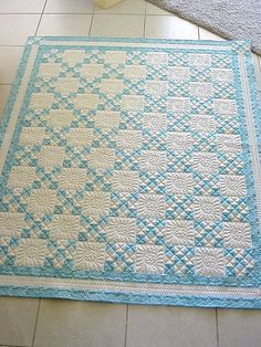 a blue and white quilt on the floor