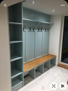 an empty room with several blue shelves and benches in the center, along with a wood floor