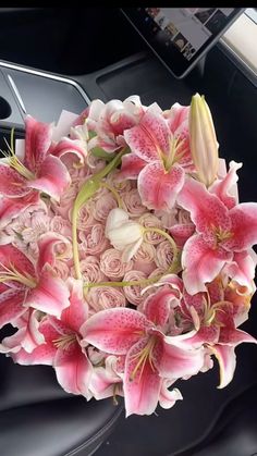 a bouquet of pink flowers sitting on top of a car dashboard