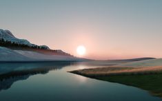 the sun is setting over a mountain range with water and grass in front of it