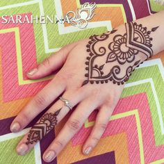 a woman's hand with henna tattoos on it